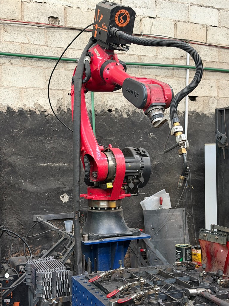 Robô de soldagem industrial Borunte com tocha de solda na área de fabricação da SteelForte